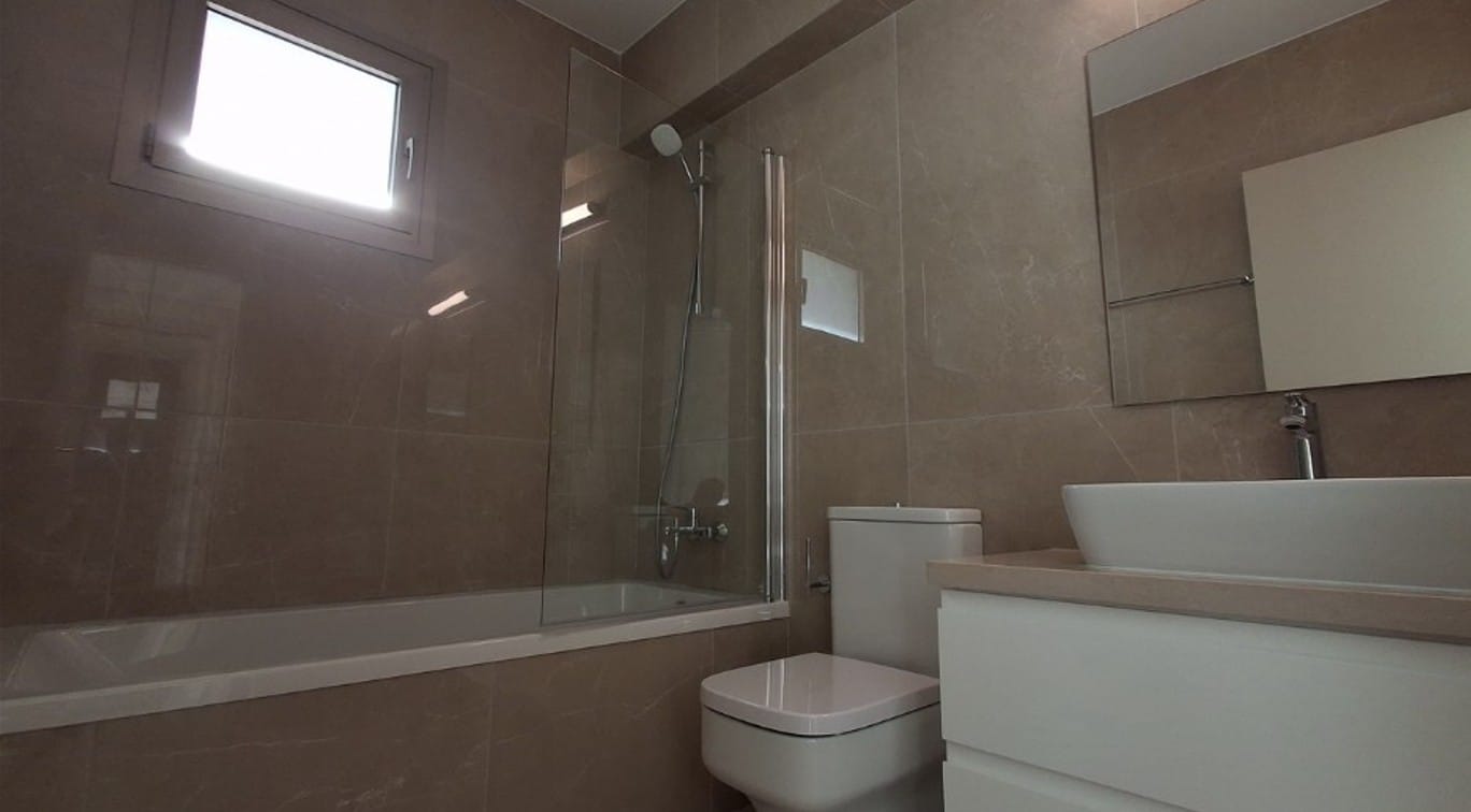 Bathroom with bathtub, glass shower screen, WC and vanity unit in an apartment in Universal, Paphos
