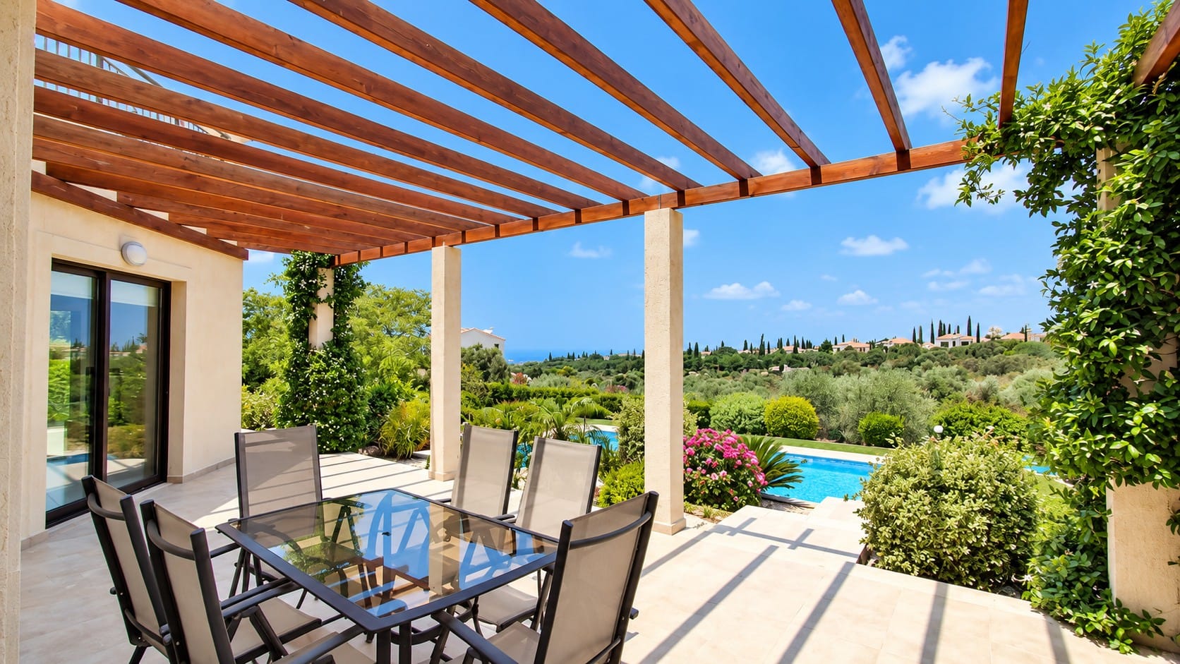 Outdoor terrace with pergola and dining set overlooking the private swimming pool, gardens and Mediterranean coastline