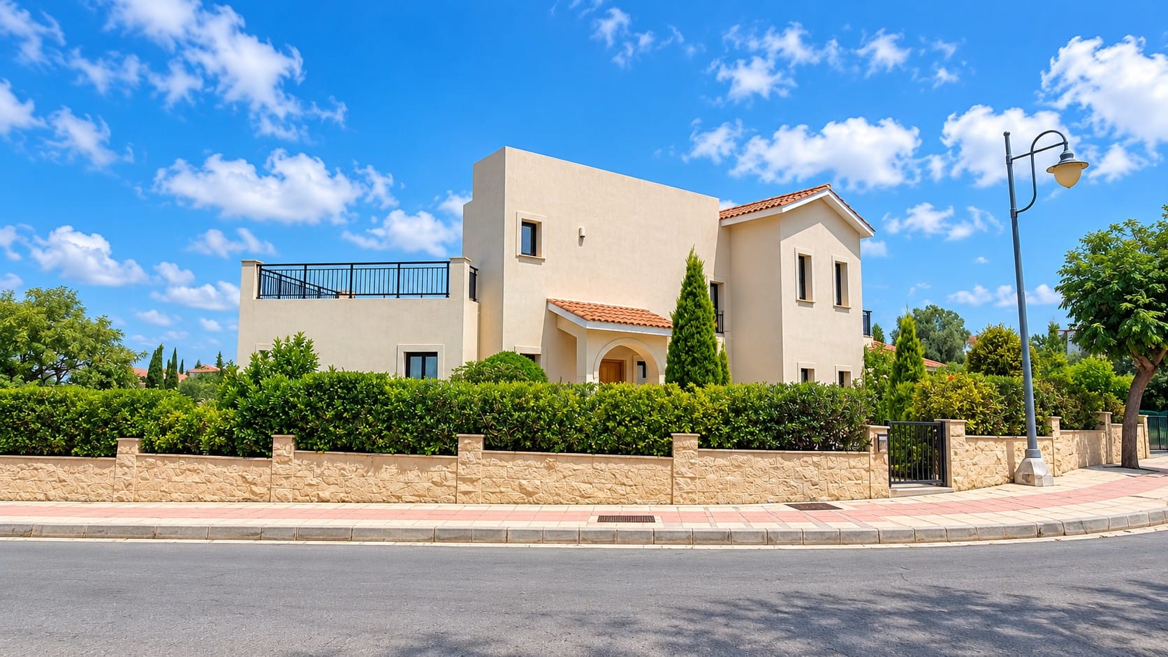 Villa exterior in Venus Rock, Paphos, with roof terrace, tiled roofs, arched entrance and stone boundary wall