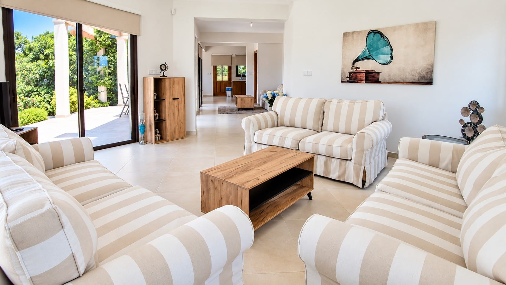 Living area with striped sofas and sliding glass doors opening onto the outdoor terrace