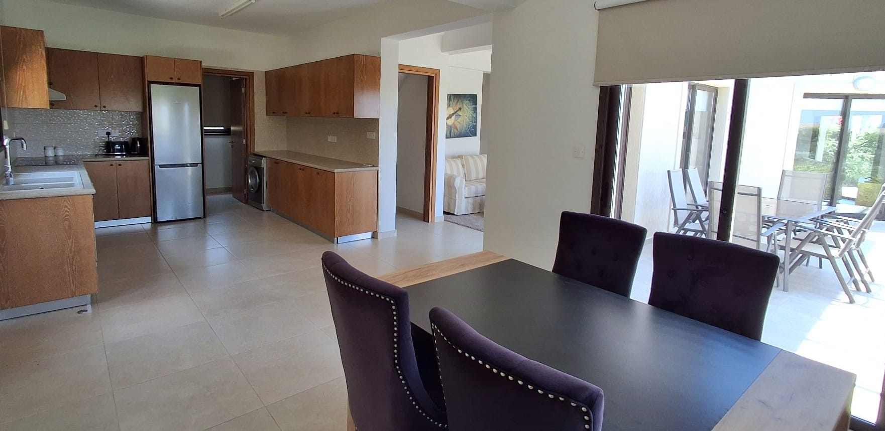Dining area beside the kitchen, with sliding doors to an outdoor terrace with seating