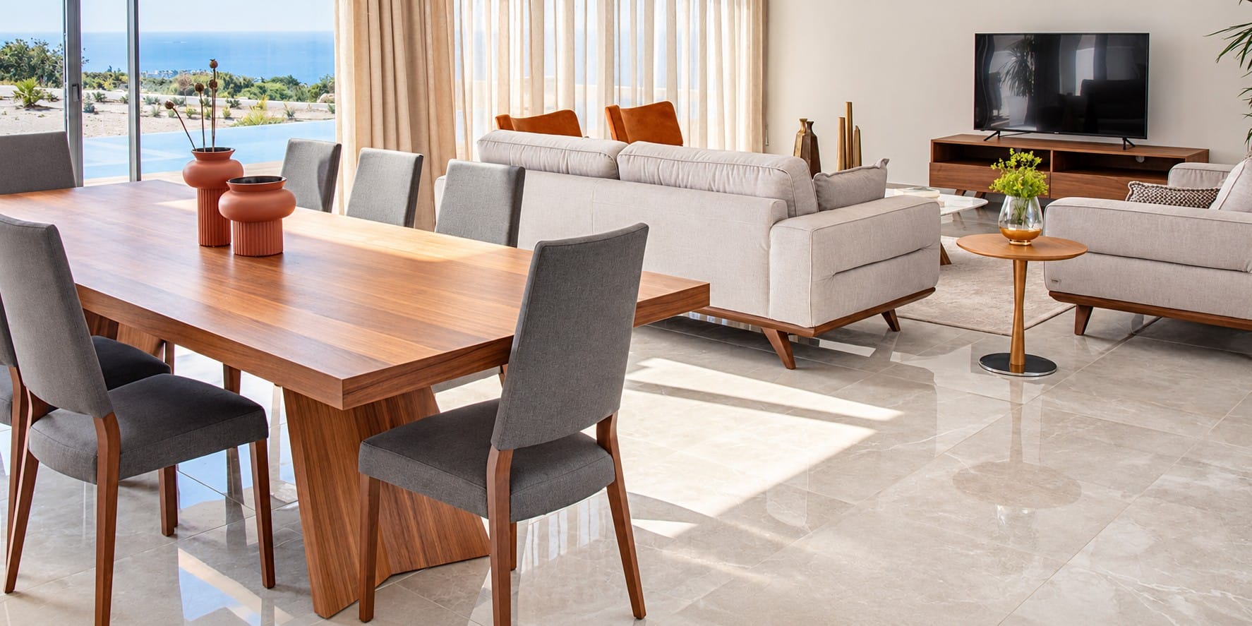 Open-plan dining and living area with marble-effect flooring and sliding glass doors overlooking a pool and the Mediterranean Sea