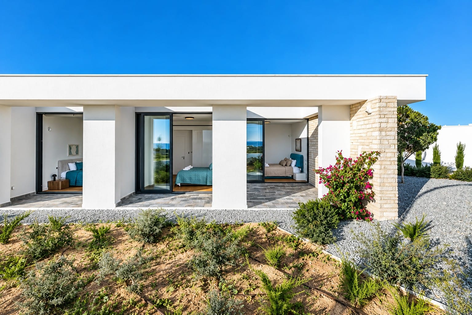 Covered terrace of a single-level villa with sliding glass doors opening into three bedrooms, with landscaped garden in the foreground