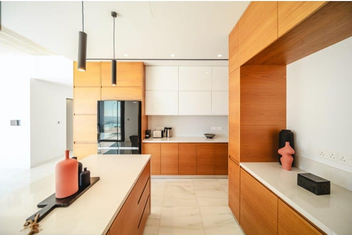 Kitchen with timber-finish and white cabinetry, island and stone-effect worktops